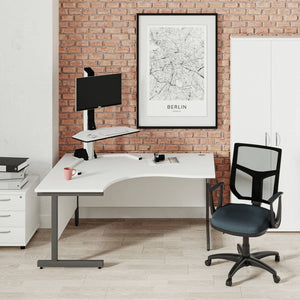 Electric sit stand desk riser on a corner desk with monitor support, designed for adjustable working in a modern office