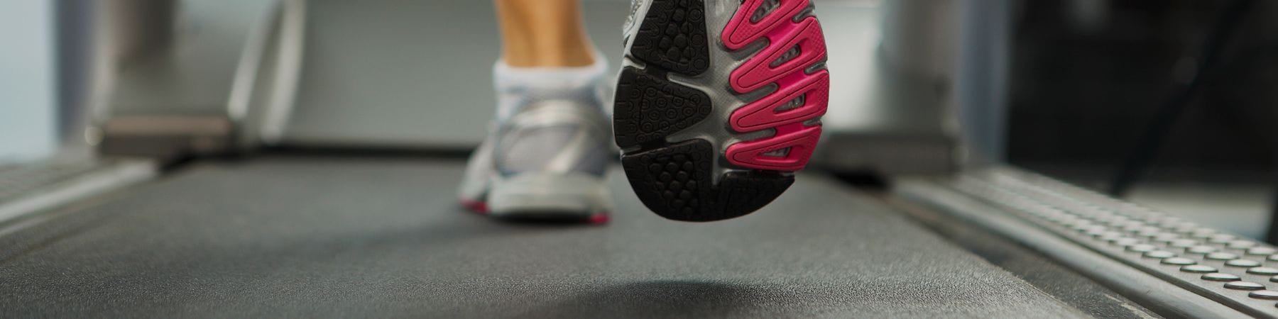 Walking on a treadmill under a desk viewed from the rear