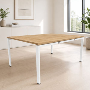 2 person dual bench desk with oak desktop and white frame shown in a bright modern office setting