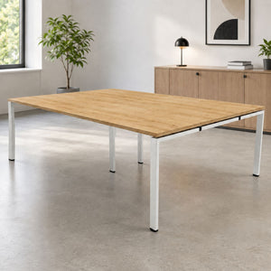 Bank of desks for 4 people with oak-effect desk top and silver frame in a clean, modern office interior