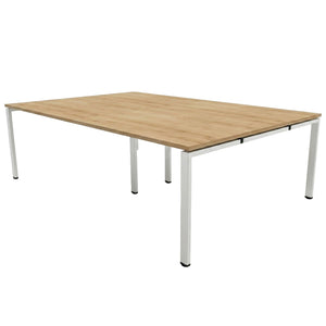 Bench desk for 4 people with oak-effect desk top and silver frame on a plain white background