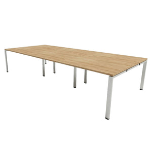 Bench desk for 6 people with oak-effect desk top and silver frame on a plain white background