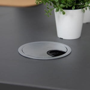 Close-up of aluminium cable port cover fitted into a desk top