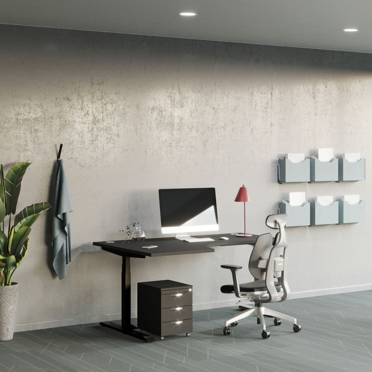 Curving standing desk with a black desk top and black frame in a modern office with an ergonomic chair