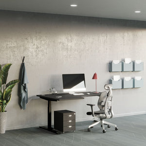 Curving standing desk with a black desk top and black frame in a modern office with an ergonomic chair