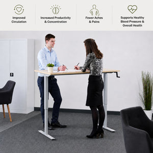 Hand crank sit stand desk used by two people with benefits for circulation, concentration, comfort and overall health