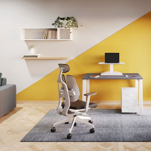 Leap electric adjustable desk converter on a desk in a stylish room with a yellow feature wall