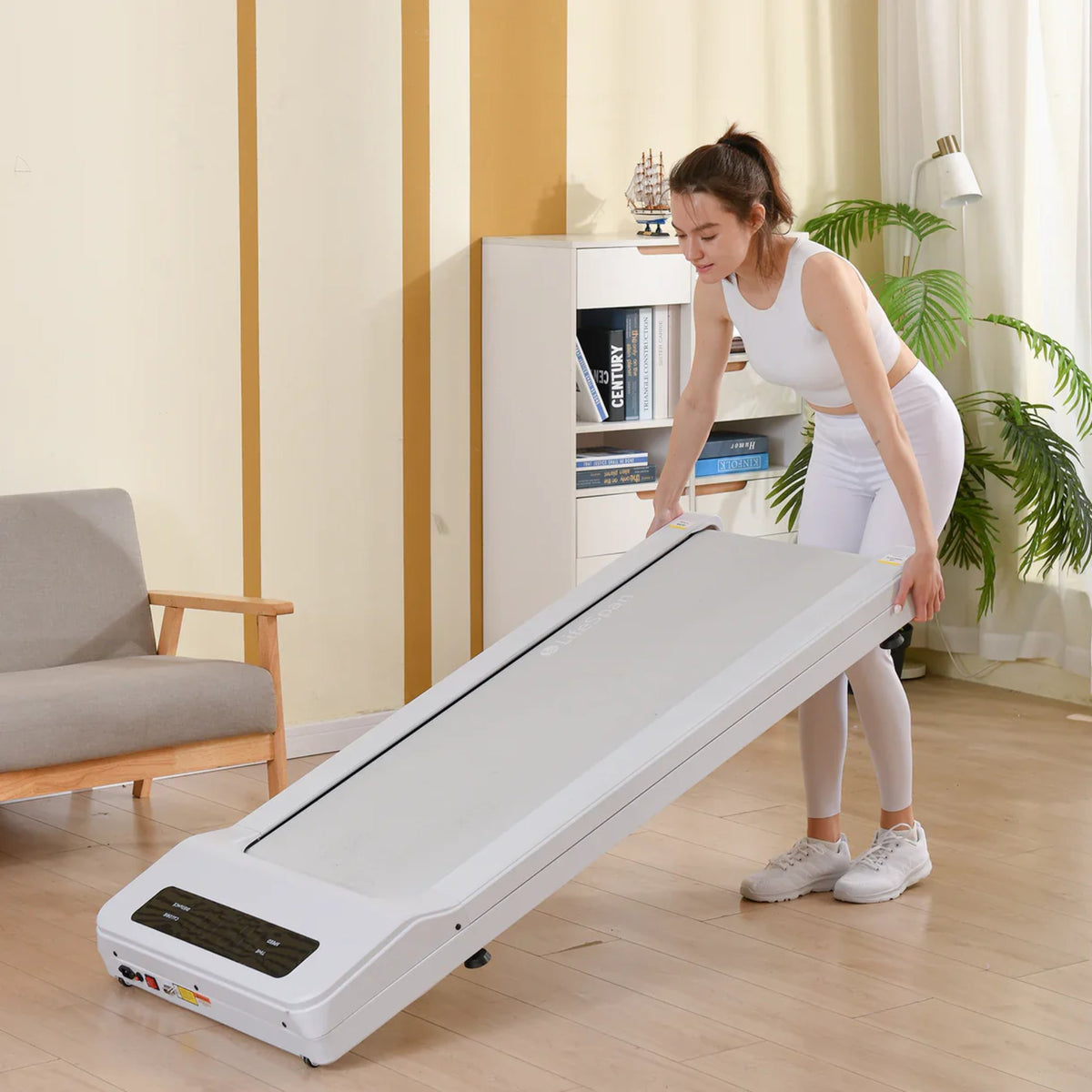 Lifespan Under Desk Walking Pad - The woman is lifting her treadmill - White Colour Variant