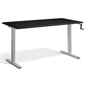 Manual crank standing desk with a black desk top, silver frame and side-mounted crank handle
