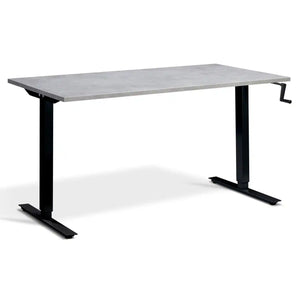 Manual crank standing desk with a light concrete desk top, black frame and hand-operated crank