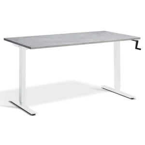 Manual crank standing desk with a light concrete desk top, white frame and hand-operated crank