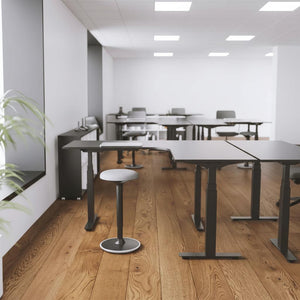 standing l-shape desks i an office placed back to back