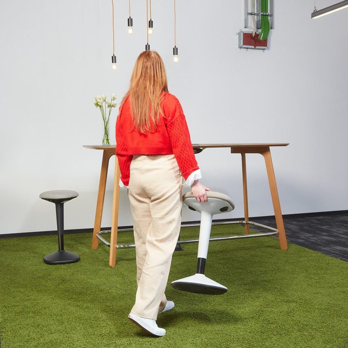 Stand Up Seat - Viasit Younit - Showing a woman carrying the seat rear view