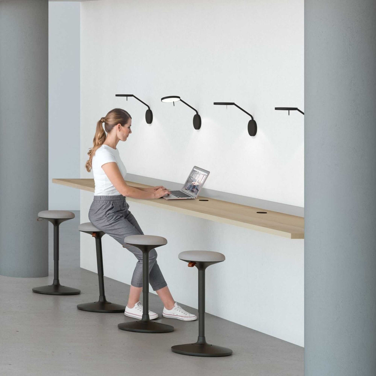 Standing Desk Stool - Viasit Cloonch - A woman working at the desk while sitting on the desk stool