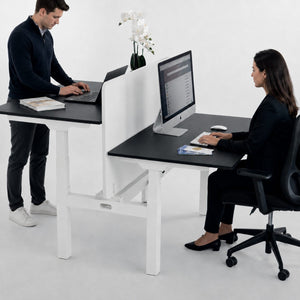 Two person standing desk with privacy screen and black desk tops in shared office setup