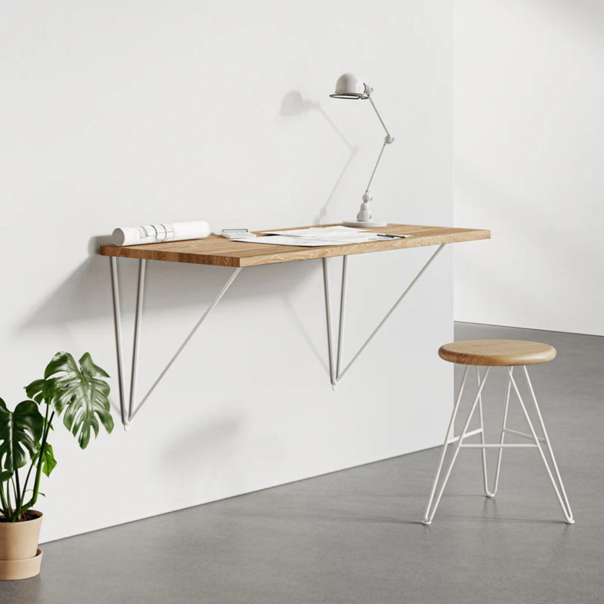 White wall desk brackets holding a wooden floating desk