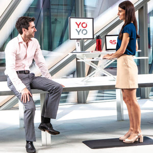 YoYo Desk 95 S - White Colour - Height Adjusted - Both Man and Woman Talking in front of the Desk