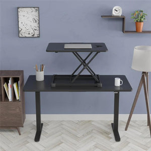 YoYo Desk Lite standing desk converter positioned on a black desk with a laptop in a modern home office