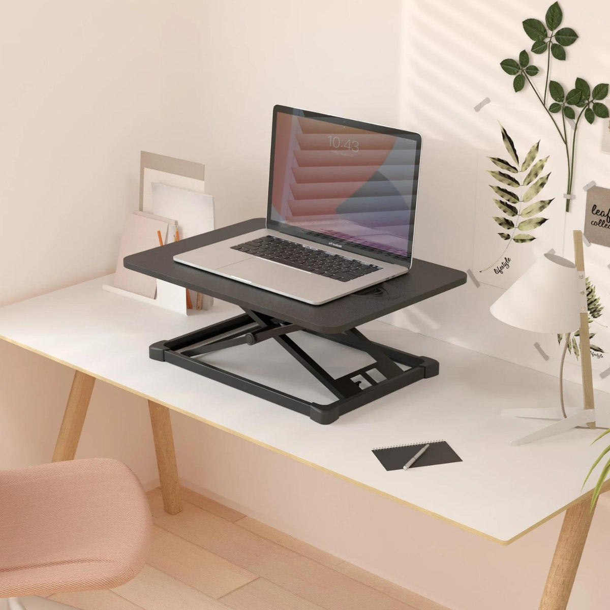 Yo Yo Desk Lite height adjustable workstation with laptop on a white desk in a bright home office