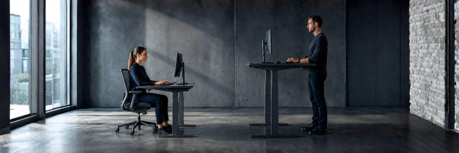 man standing at adjustable desk with woman sitting at an adjustable desk - showing ideal ergonomic heights