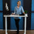 Woman standing at electric sit stand desk viewed from front