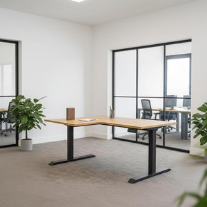 L-shaped sit stand desk with black legs in an office setting