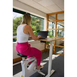 Woman using under desk exercise bike at a standing desk