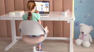 Girl sitting at Dextro white glass standing desk