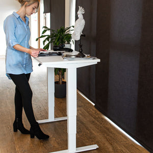 Woman using Pacto 100 cm standing desk